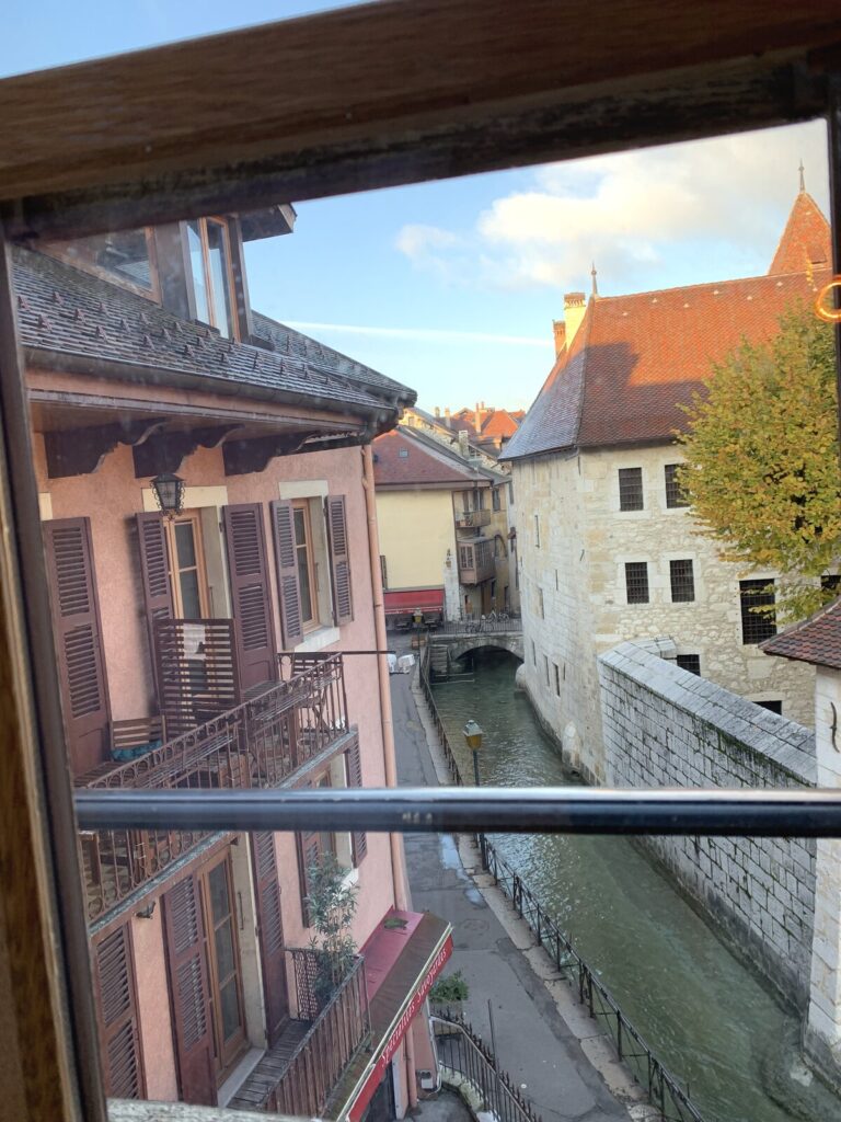 窓から見たアヌシー旧市街の運河とカラフルな建物