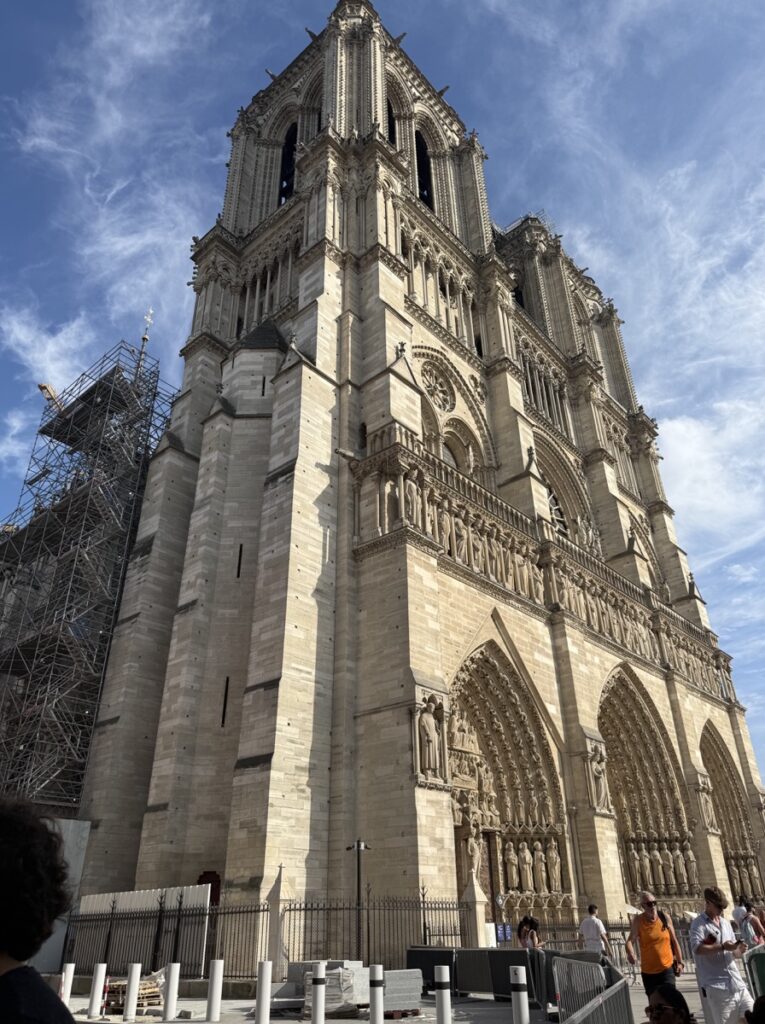 フランス・パリのノートルダム大聖堂。二つの塔とバラ窓、三つの入口が特徴的なゴシック建築のファサード（2025年、再開後）